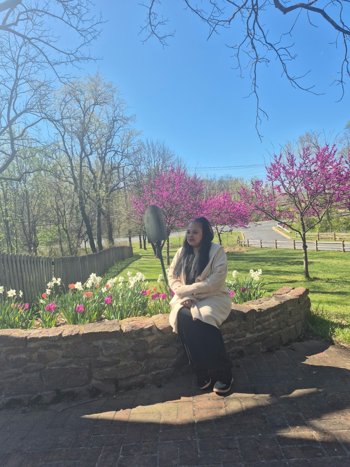 Taria seated beside flowering trees in a garden
