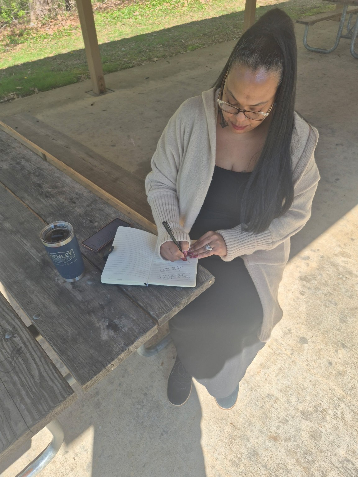 Original photograph of Taria writing in her notebook outdoors